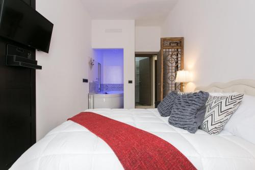a bedroom with a white bed with a red blanket at Aparthotel Dei Mercanti in Milan