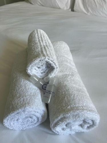 a white towel sitting on top of a bed at CapePod City Centre in Cape Town