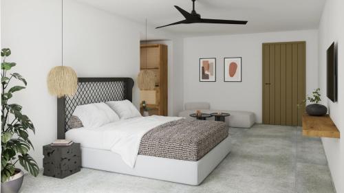 a white bedroom with a bed and a potted plant at Aelo Mykonos Hotel in Paradise Beach