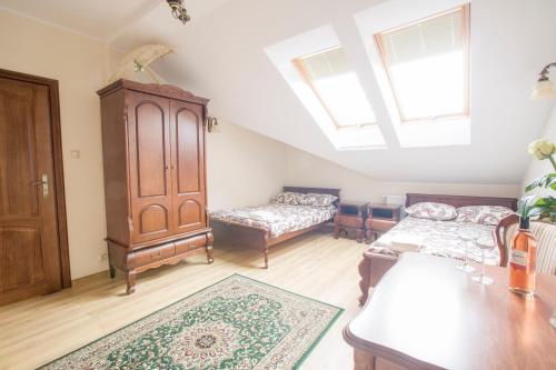 a living room with two beds and a dresser at Dworek Stara Szkoła in Bełchatów