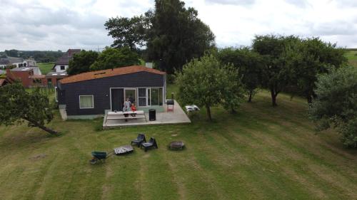 a person sitting on a porch of a tiny house at Haaghoek, design vakantiewoning in Horebeke