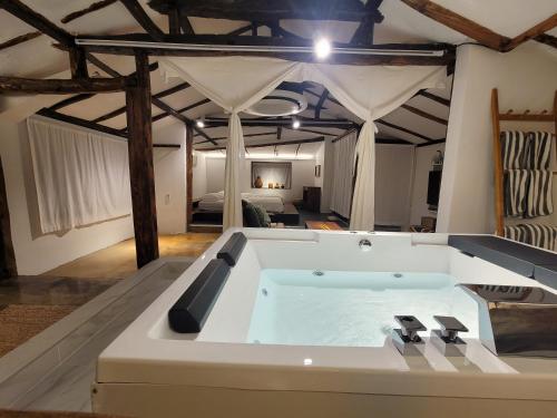 a large bath tub in a room with a bedroom at Green Casa in Seogwipo