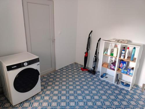 - une buanderie avec un lave-linge et une étagère dans l'établissement Luminosa, à Vaison-la-Romaine