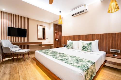 a bedroom with a bed and a desk and a television at Holitel Anjuna in Arpora