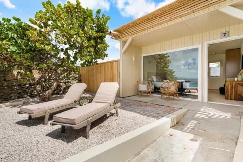 a patio with two lounge chairs and a house at Boutique Hotel Bougainvillea in Kralendijk