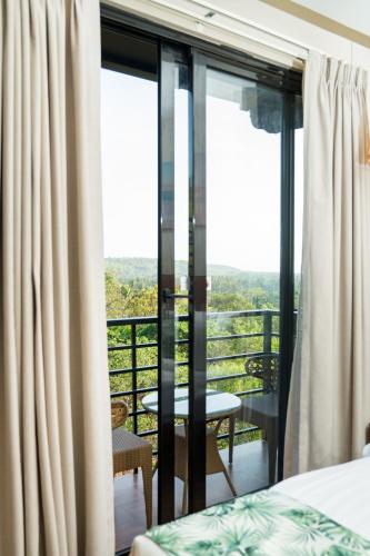 a bedroom with a view of a balcony at Holitel Anjuna in Arpora