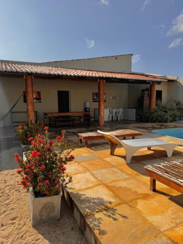 a patio with benches and a pool and a house at Palmeira’s du Vento in Cruz