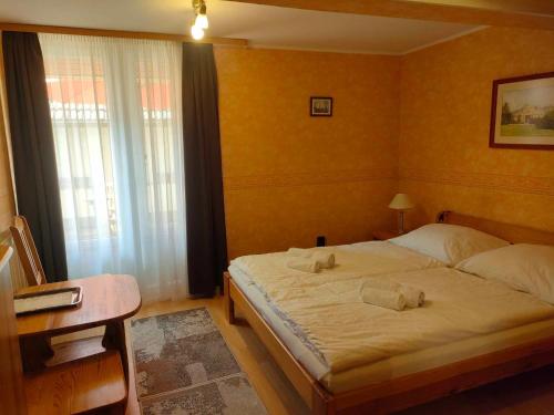 a bedroom with a bed with two towels on it at Czérna Vendégház in Tata