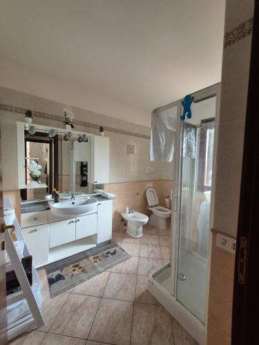 Un baño con ducha, lavabo e inodoro. en ELAIA HOUSE, en Capoterra