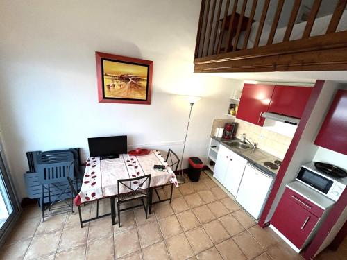 une petite cuisine avec une table et un ordinateur portable. dans l'établissement Apt 4 pers - Magnifique vue mer - Terrasse - 50 m de la plage - Bleuenn, à Le Fort-Bloqué