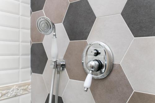 a shower with a shower head on a wall at Aparthotel Dei Mercanti in Milan