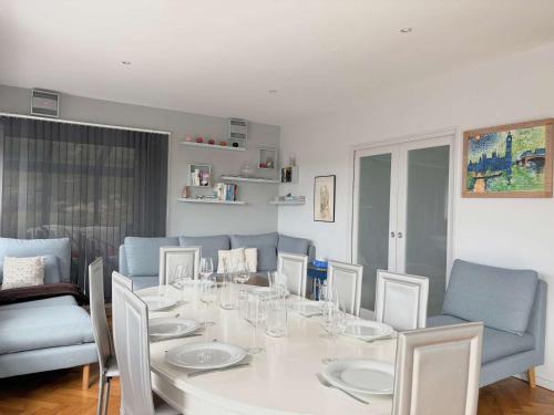 une salle à manger avec une table et des chaises blanches dans l'établissement Superbe maison avec jardin, proche plage, chiens admis - FR-1-542-25, à Trébeurden