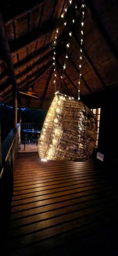 a large chandelier is hanging from a ceiling at Amare Cabin in the bush with all your needs! in Marloth Park