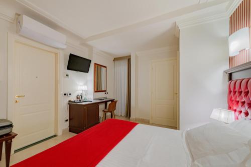 a bedroom with a bed and a desk with a computer at La Paloma Blanca Hotel in Sciacca