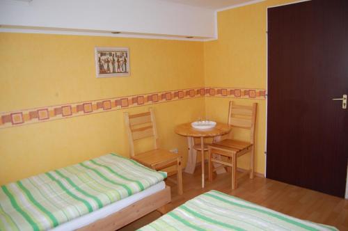 a small room with two beds and a table at Czérna Vendégház in Tata