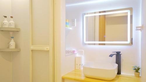 une salle de bains avec un lavabo et un miroir dans l'établissement Yuina Hotel Shinjuku, à Tokyo