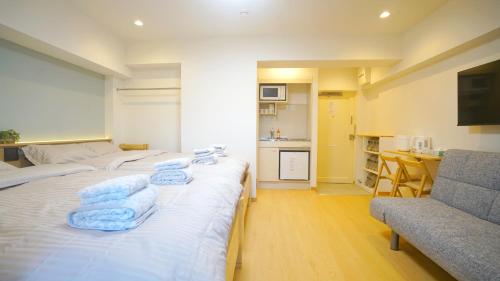 une chambre d'hôtel avec deux lits et un canapé dans l'établissement Yuina Hotel Shinjuku, à Tokyo