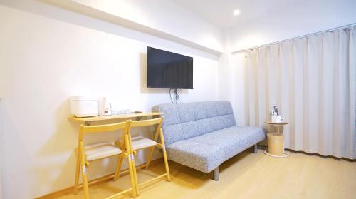 a room with a chair and a desk and a tv at Yuina Hotel Shinjuku in Tokyo