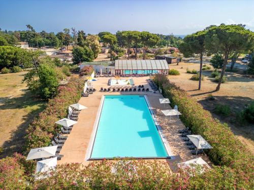 une vue aérienne d'une piscine avec chaises et parasols dans l'établissement Camping Domaine d'Anghione, à Castellare-di-Casinca