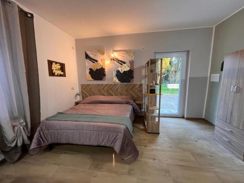 a bedroom with two beds and a sliding glass door at Nel giardino segreto vista giardino in San Giorgio a Liri