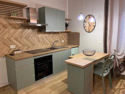 a kitchen with a table and a clock on the wall at Nel giardino segreto vista giardino in San Giorgio a Liri