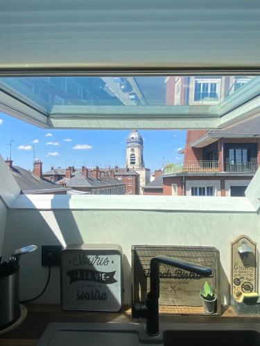 a window in a kitchen with a view of a city at "LE COCON" en HYPERCENTRE PARKING GRATUIT in Amiens