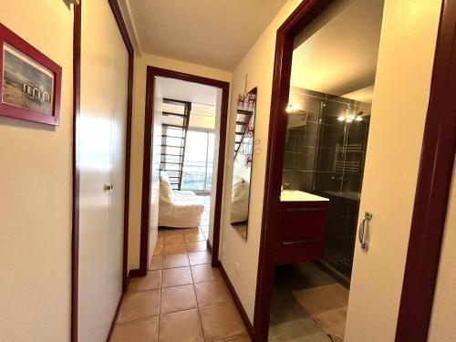 - un couloir avec une salle de bains pourvue d'une douche et d'un miroir dans l'établissement Apt 4 pers - Magnifique vue mer - Terrasse - 50 m de la plage - Bleuenn, à Le Fort-Bloqué