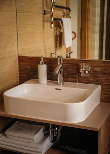 a white sink in a bathroom with a mirror at Agneta Apartamentai in Druskininkai