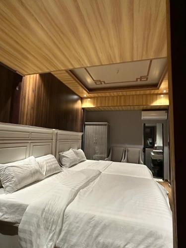 a bedroom with a large white bed with a wooden ceiling at Kim Đồng Riverside in Trại Lê Lai