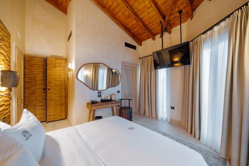 a bedroom with a large white bed and a mirror at Arctic Boutique Hotel in Korçë