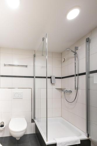 a bathroom with a shower and a toilet at Globana Airport Hotel in Schkeuditz