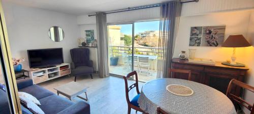un salon avec un canapé, une table et une télévision dans l'établissement Charming T2 with balcony near the port of Fréjus, à Fréjus