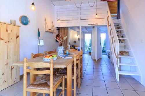 une cuisine et une salle à manger avec une table et des chaises en bois dans l'établissement Maison Aturine - Welkeys, à Capbreton