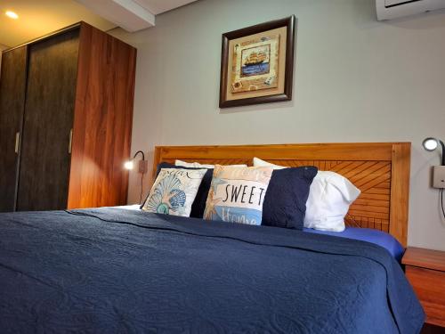 Azur Horizon Residence في فليك-إن-فلاك: غرفة نوم بسرير وملاءات ووسائد زرقاء