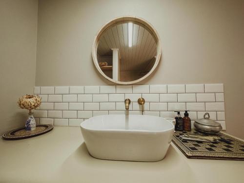 a bathroom with a white sink and a mirror at Buena Vista in Struisbaai in Struisbaai