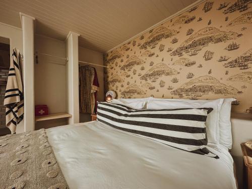 a bedroom with a large white bed with a wall at Buena Vista in Struisbaai in Struisbaai