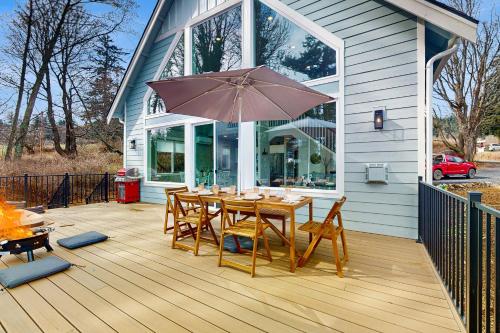 a wooden table with an umbrella on a deck at Heron's Landing in Lummi Island