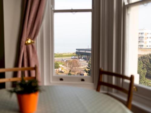 a table and a window with a view of a parking lot at Snug Sea View 2 Bed Apartment - Margate Pass the Keys in Margate
