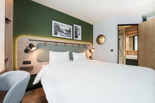 a bedroom with a white bed and a green wall at Campanile Blanc-Mesnil in Le Blanc-Mesnil
