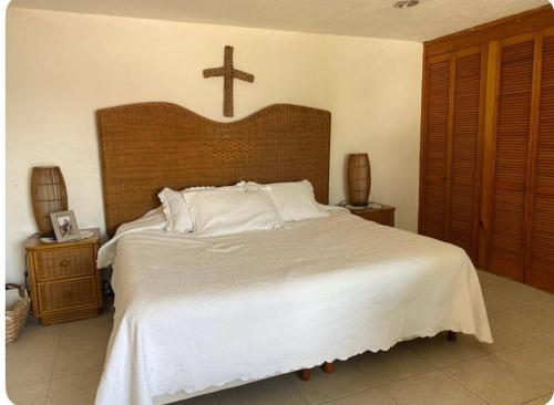 - une chambre avec un grand lit surmonté d'une croix dans l'établissement House on the shore of the lake, à Tequesquitengo