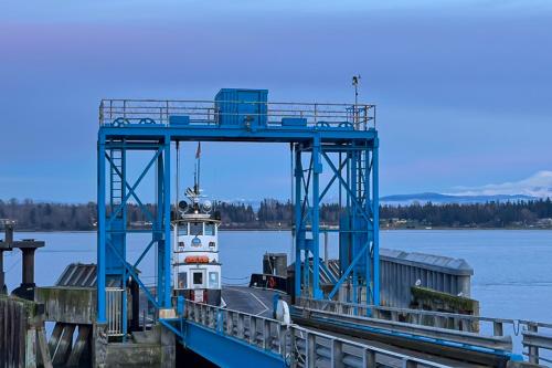 a boat docked at a dock with a lighthouse at Heron's Landing in Lummi Island