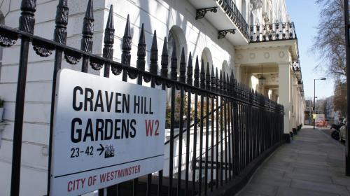 a sign on a fence in front of a building at Caring Hotel in London