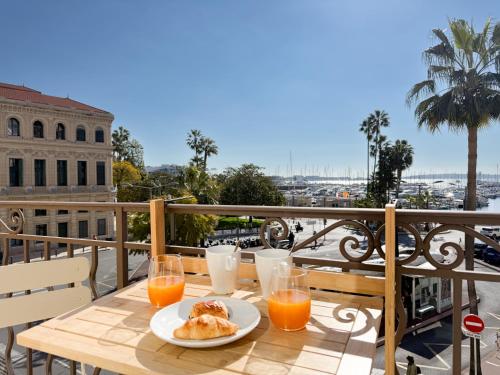 une table avec une assiette de nourriture et du jus d'orange dans l'établissement 5A - APARTMENT FACING PORT & Town Hall, à Cannes