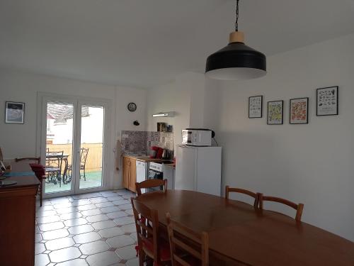 une cuisine et une salle à manger avec une table et un réfrigérateur dans l'établissement Gite 