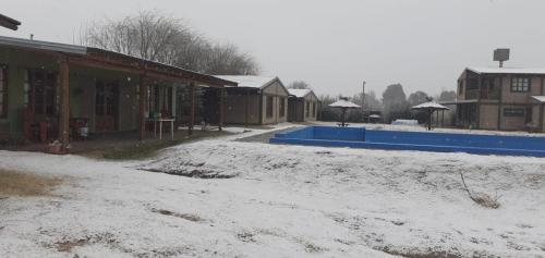a pool is covered in snow next to a building at Cabañas Las Bahienses in San Rafael
