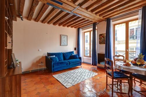 un salon avec un canapé bleu et une table dans l'établissement BnBNova - 1BR - The Heart of Le Marais, à Paris