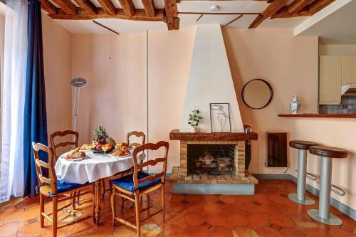 une salle à manger avec une table et une cheminée dans l'établissement BnBNova - 1BR - The Heart of Le Marais, à Paris