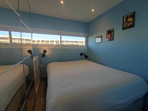 une chambre avec un lit blanc et une fenêtre dans l'établissement Appart 76, Port Nature Colline 2 Village Naturiste, au Cap d'Agde