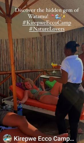 a man standing next to a bed with two girls at Kirepwe Ecco Camp Watamu in Watamu