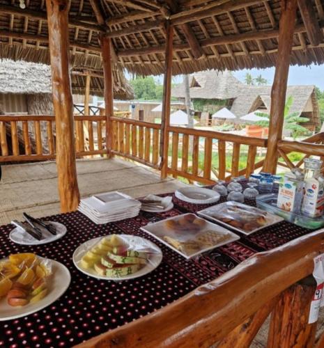 a table with plates of food on top of a table at Kirepwe Ecco Camp Watamu in Watamu